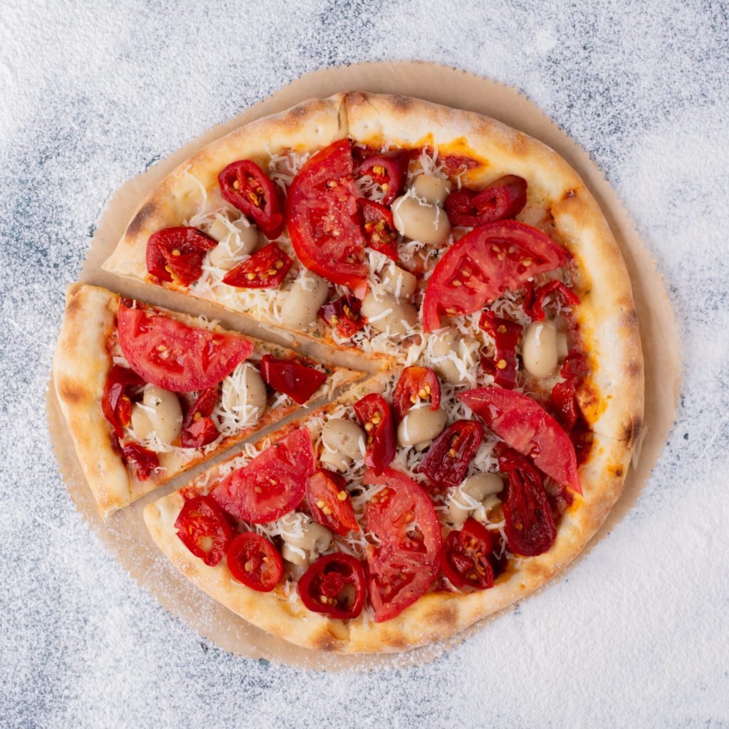 Delicious chicken pizza with tomatoes on marble background. High quality photo